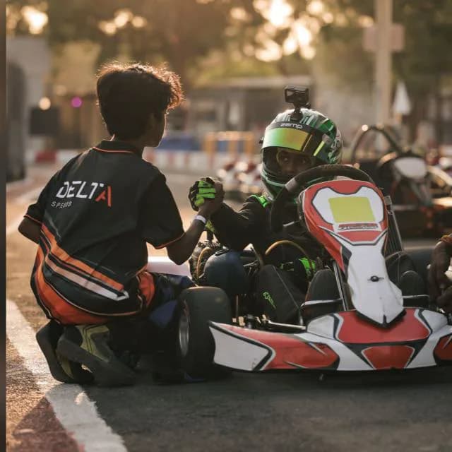 A handshake with a rival driver in the paddock at sunset